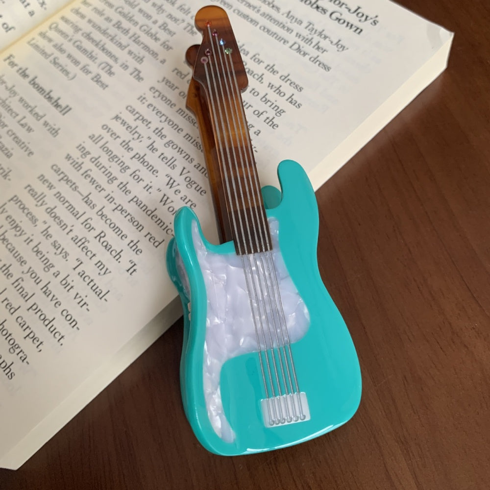 Blue acoustic guitar-shaped hair claw clamp by Alorar, featuring intricate detailing and a sturdy grip for hair styling.