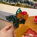Green-tailed goldfish claw clamp hair clip by Alorar, featuring intricate design and vibrant colors.