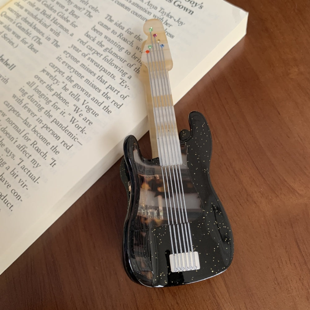 Black acoustic guitar-shaped hair claw clamp by Alorar, featuring intricate design and sturdy grip for securing hair.